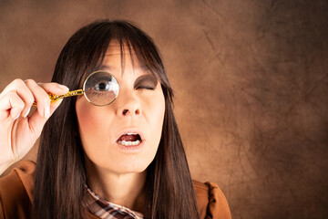 Nahaufnahme einer Frau mit Vergr&ouml;&szlig;erungsglas &ndash; Blick f&uuml;r Details