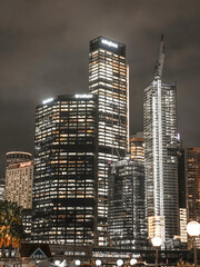 Naklejka premium Sydney CBD Rainy Night Skyline with Illuminated High-Rise Buildings