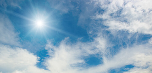 Natural daylight image with sun rays, bright sky, and varied cloud cover evoking serene and peaceful mood