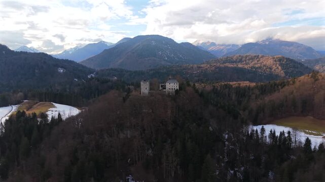 Drone footage of Burg Thierberg, a medieval hilltop castle near Kufstein, Austria. Snowy alpine scenery with views of the Inn River, Kaisergebirge mountains and surrounding valleys.