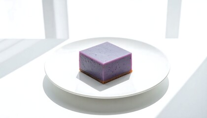 A single purple cube dessert on a white plate.