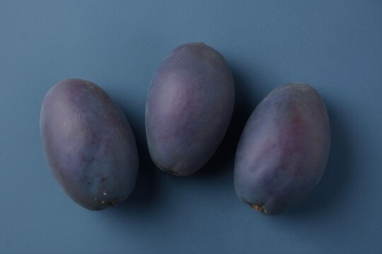Fresh purple African pear dika resting on a deep blue backdrop evoke a sense of tropical delight and vibrant flavors