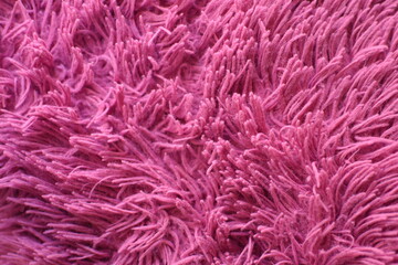 Fototapeta premium Soft pink and fuchsia plush fabric texture. Close up of furry textile showing fluffy, cozy surface with vibrant colors, perfect for backgrounds or creative designs.