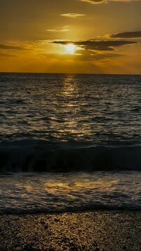 Majestic golden sunset over the tranquil ocean, with sunbeams piercing through the clouds and reflecting on the gentle waves of the sea