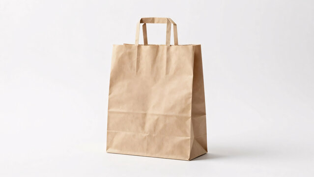 A classic, blank brown kraft paper shopping bag with flat handles stands upright against a clean white background, providing an ideal template for retail packaging and branding mockups.