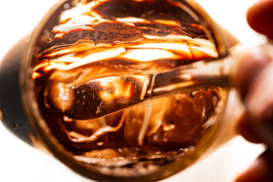 Closeup of the inside of a nearly empty jar of hazelnut spread with a silver butter knife inside