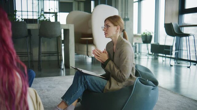 Women engage in discussion during psychology session aimed at personal growth and support in contemporary office setting