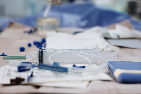 Close-up of sterile anesthesia and central line instruments on an operating room table. Shallow depth of field highlights medical supplies for catheter placement, invasive procedures, and preparation.