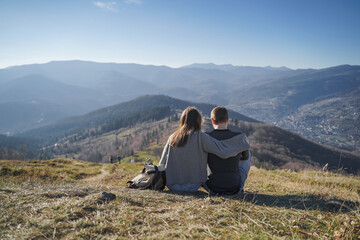 Fototapeta premium Couple Sitting on Mountain Hill Enjoying View