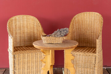 Ancient Roman wicker chairs and wooden table with lavender basket