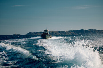 the coast of the Barents Sea, pleasure boats in the sea, the rocky shore with colourful arctic carpet of moss, yagel, Tundra at autumn © Vladimir Drozdin