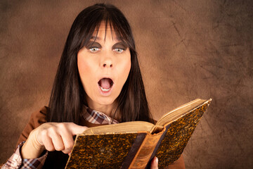 Frau mit erstauntem Gesichtsausdruck beim Lesen in einem alten Buch