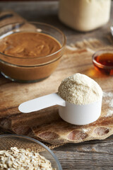 Fototapeta premium Whey protein powder, oat flakes, peanut butter and maple syrup - ingredients for homemade protein snacks