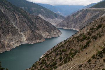 Fototapeta premium Stunning aerial view of a turquoise river winding through steep mountain canyons.