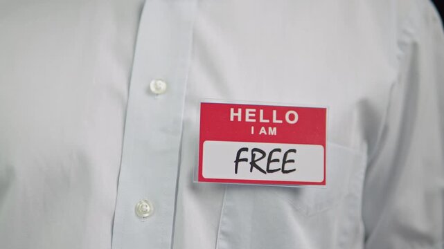 Red hello badge on chest reads free.An indepth look at greeting badge and light shirt fabric