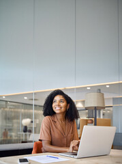 Obraz premium Happy young African American business woman employee using laptop at work in office. Professional busy businesswoman executive, company worker or manager looking away working at computer. Vertical