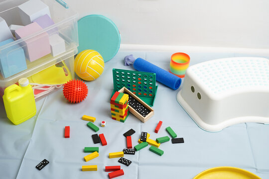 Colorful array of therapeutic tools for child development. High-angle view of blocks, balls, games for pediatric occupational and physical therapy. For motor skills and sensory integration.