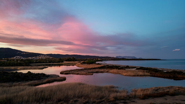 Sunset over Li Salineddi Pond with Tavolara Island on the horizon, Budoni, Sardinia, Italy.
