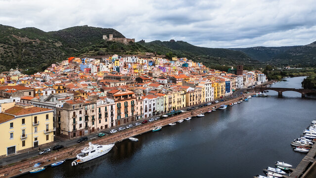 Panoramic view of Bosa with colorful houses, Temo River, and Malaspina Castle, Sardinia, Italy.