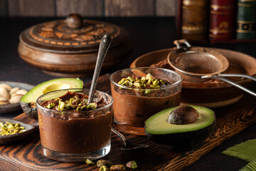 Servings of chocolate avocado mousse garnished with chopped pistachios.