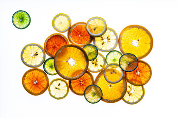 An arrangement of sliced lemon, limes and oranges against a white background.