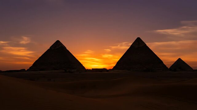 Ancient pyramids silhouetted against a stunning desert sunset