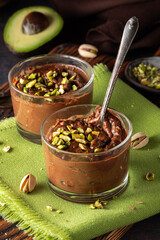 Healthy chocolate avocado mousse servings sprinkled with chopped pistachios.