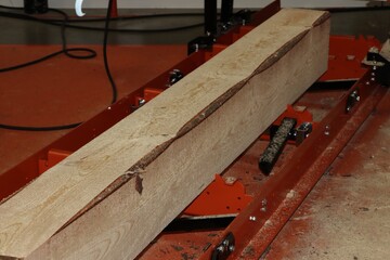 A large log being milled into lumber on a portable sawmill. © Miroslav
