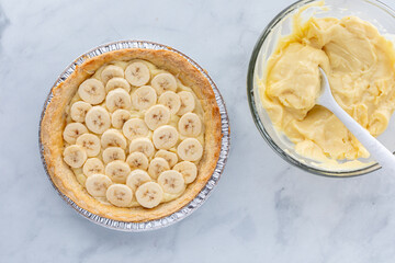 A homemade banana cream pie ready for the vanilla custard pudding filling.