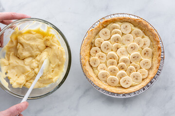 Hands stirring the vanilla pudding custard for making banana cream pie.