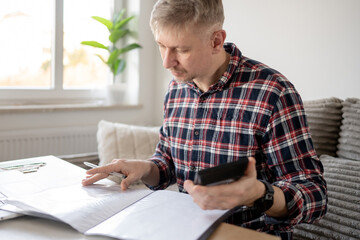 Fototapeta premium Man Working Remotely From Home With Documents