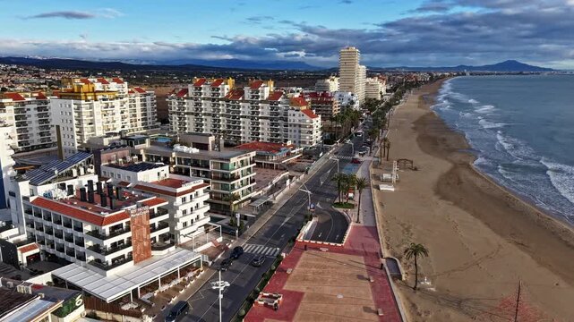 Seafront promenade in Pe&ntilde;&iacute;scola Spain aerial drone view over sandy beach and palm lined waterfront at sunset light