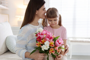 Happy Mother's Day. Mom and her daughter with bouquet of beautiful flowers at home