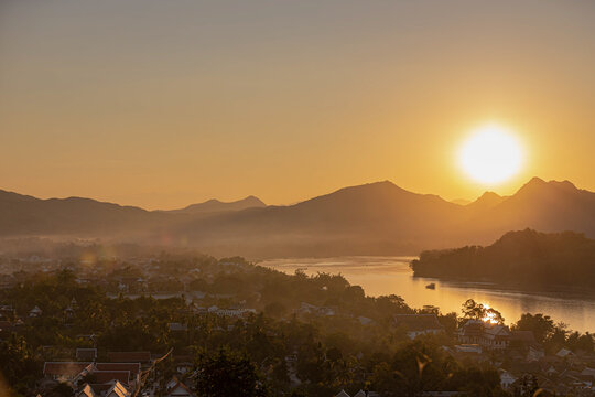 Stunning view of Phousi hill accessible by hiking, This summit with sweeping views is a well-known spot to watch sunset, Golden sunlight in evening while the sun goes down, Luang Prabang city, Laos.
