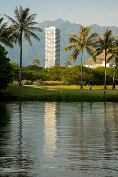 USA, Hawaii, Honolulu, Waikiki.  Tall apartment building reflecting in the Ala Wai Canal.