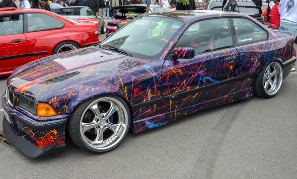 Highly customized BMW E36 coupe is head turner, featuring aggressive, low slung stance and vibrant, multi color paint splatter style vinyl wrap that commands attention