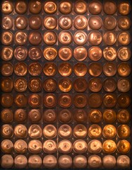 Grid of bronze-toned circular forms, each with a unique texture