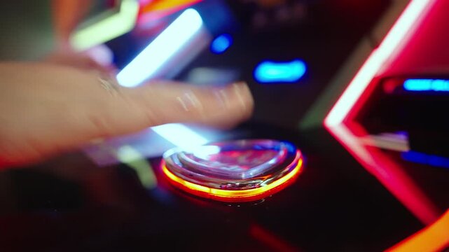 Close up of hand pressing illuminated casino slot machine button under colorful neon lights. Gambling moment of risk excitement and chance in modern gaming hall.