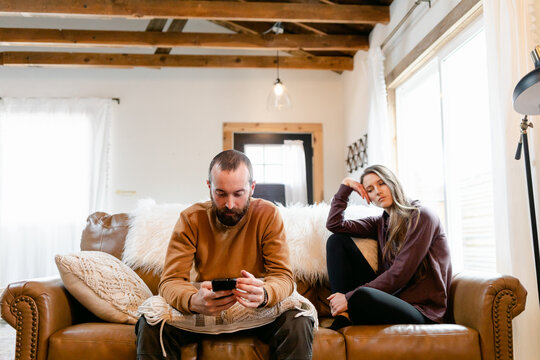 Man Scrolling on His Phone While His Wife is Bored