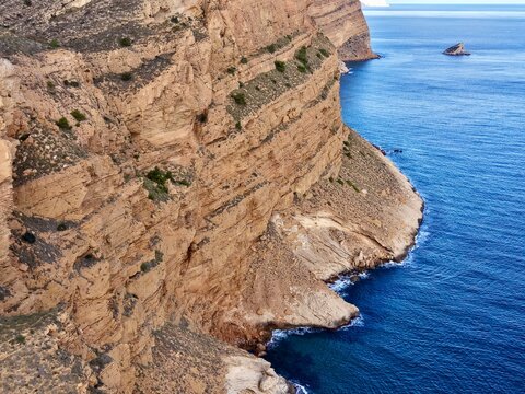 Imposing rock face beside azure sea offering breathtaking vistas and photographic opportunities
