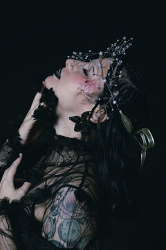 Editorial portrait of a goth woman with a tiara on her face 