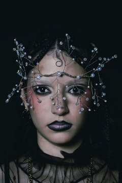 Editorial portrait of a goth woman with a tiara on her face 