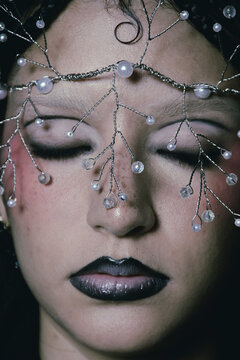 Editorial portrait close up of a gothic woman with a tiara and make up