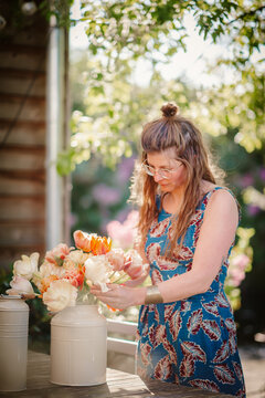 woman organizing flowers in a vase outdoors