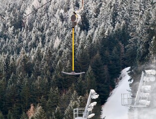 Mountain lift scene. Alpine gondola cabin hanging above snowcovered woods during foggy mountain descent © Vladimir