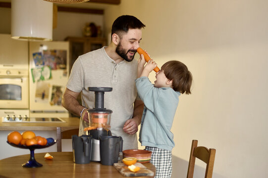 a dad has a fun with his son in a kitchen