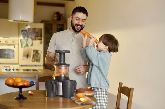 a dad has a fun with his son in a kitchen