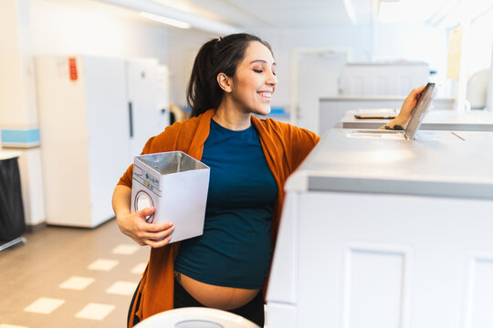 Young pregnant woman doing laundry