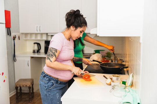 Pregnant woman cooking in kitchen room