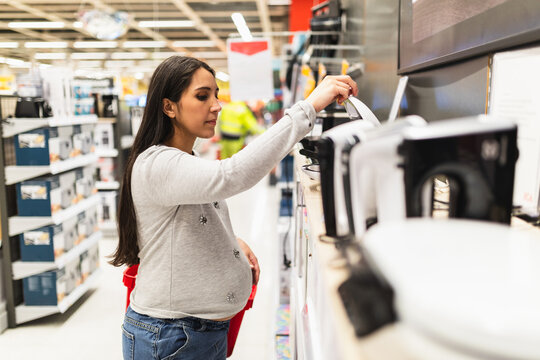 Pregnant woman looking at home appliances in store